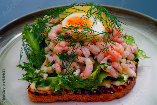 Traditional Scandinavian shrimp toast (toast Skagen) with dill, egg and mayonnaise