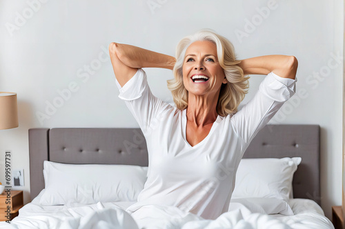 happy mature woman doing pull-ups after waking up in bed.