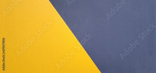 The cement walls are painted blue and yellow. clearly separated on the diagonal It is yellow on the bottom and blue or gray on the top. The background wall is painted differently. 