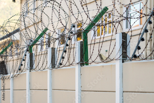 electric fence with razor wire or barbed wire on a perimeter wall close up concept safety and security