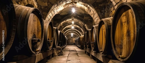 Aging wine in La Rioja, Spain, using old oak barrels in cellars.