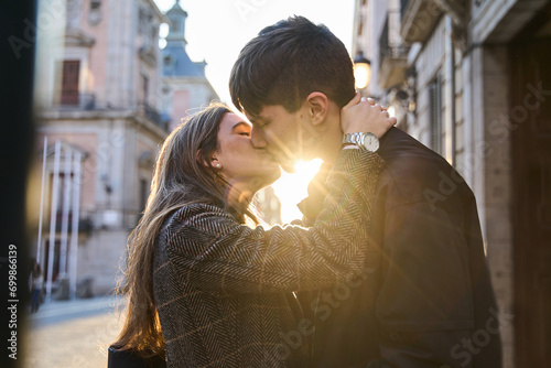 two lovers kissing in the street at sunset. young couple spending valentine's day as a couple.