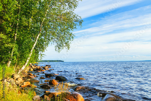 Summer sunny landscape of the rocky shoreline near the large Lake Onega in Karelia.