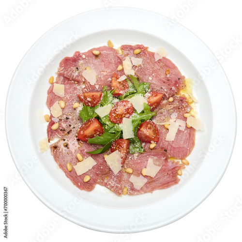 cooking tuna carpaccio - cherry tomato pieces on a plate with raw tuna fillet slices