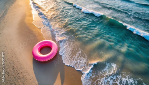 Sunset vibes: A pink float on a sandy beach from above.