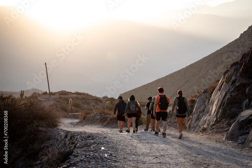 Grupo de amigos haciendo senderismo por caminos montañosos de Tilcara, Jujuy