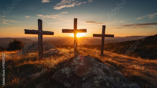 three wooden chrsitian crucifix crosses on hill at sunset