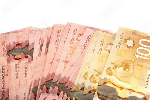 A stack of candian bills of different denomination on a white background. Synonymous with wealth and abundance.
