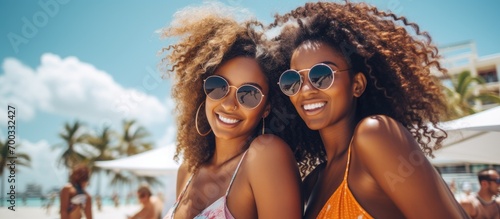 Black women friends in an urban city enjoying a summer vacation in sunny Miami. Happy travel couples or young people smiling near the ocean for vitamin D.
