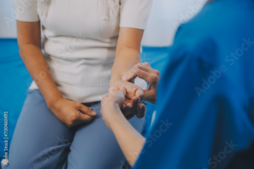 Young asian caretaker with 60s asia elderly woman consulting and encourage, take a history and recommend the right treatment, holding hands and encouraging