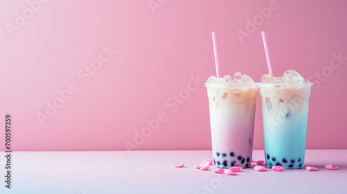 Plastic clear glass with delicious milk tea with tapioca balls. Milk bobba cold tea, summer drink on flat pink background with copy space, banner template.