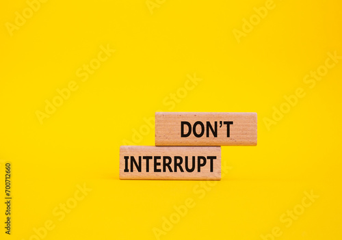 Dont interrupt symbol. Concept word Dont interrupt on wooden blocks. Beautiful yellow background. Business and Dont interrupt concept. Copy space