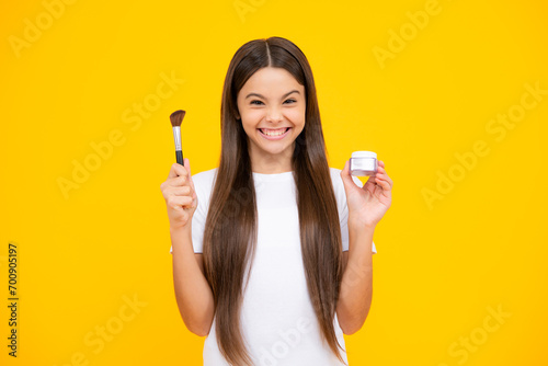 Child teen girl making beauty make up, hold powder and brush. Beautiful teenager applying makeup with powder. Happy teenager portrait. Smiling girl.