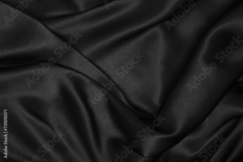 Part of the dark fabric texture of the fabric for the background and decoration of the work of art, a beautiful crumpled pattern of silk or linen. A crumpled piece of cloth