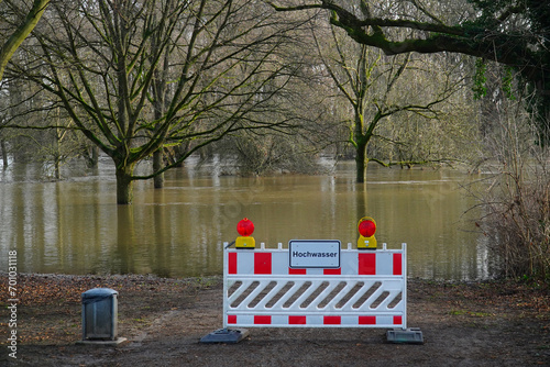 German warning sign in front of a path that ends in the flood waters of the river Leine. Hochwasser (High Water) near Hanover Marienwerder, Germany. 