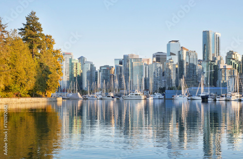 The Seawall and the skyline of Vancouver as seen from Stanley Park during a golden hour sunset in the fall in British Columbia, Canada