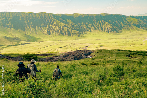 A group of hikers against mountains and valleys at Mount Ol Doinyo Lengai in Tanzania