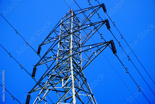 Steel electricity Pylon and High Voltage Power line Electricity transmission photo with blue sky background.