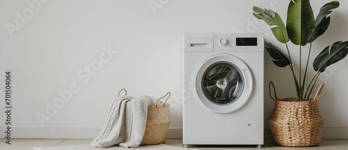 Elegant washing machine and laundry basket next to clean white wall