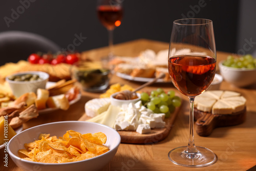 Rose wine and appetizers served on wooden table, space for text