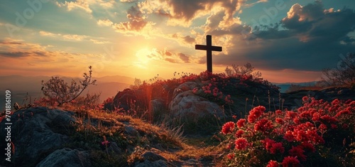 Cross on top of hill with red rhododendron flowers at sunset