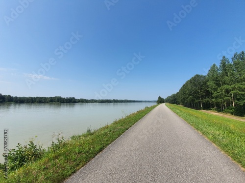 Beautiful bike path at famous Danube River: Donauradweg next to the river on a sunny day with clear blue sky and copy space for text, austria