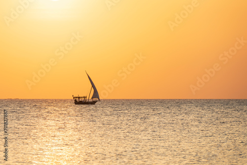Summer concept, dhow boat sails in the ocean at sunset, Zanzibar, Tanzania.