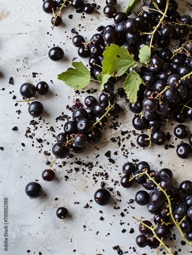 A spill of blackcurrants on a marble surface, with some berries rolling away.