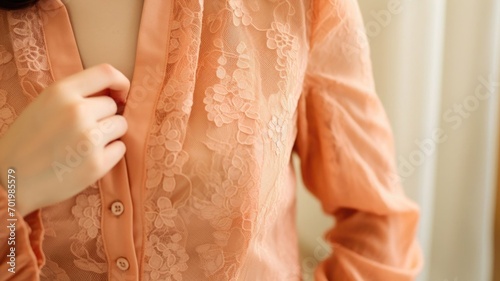 Closeup of a Peach Fuzz lace blouse, with a delicate lace collar and lace sleeves for a soft and romantic feel.