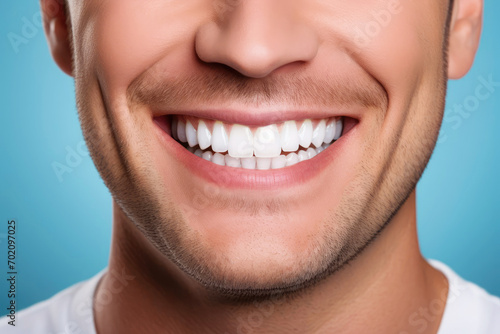Beautiful smile of a young man on a blue background close-up