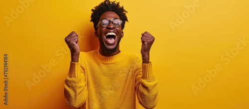 A happy young man raises his hands in elation Reaction after hearing good news. with copy space image. Place for adding text or design