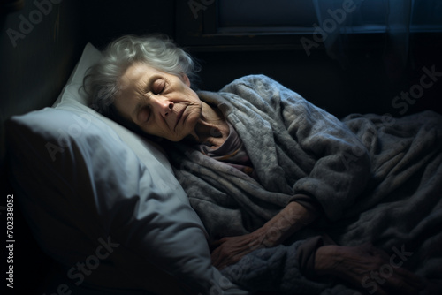 elderly woman sleeping on bed in dark room, blurred background