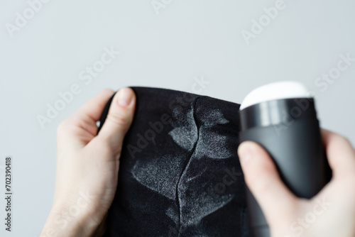 Unrecognizable woman holding black clothes with deodorant stains. Spoiled clothes. daily life stain concept. 