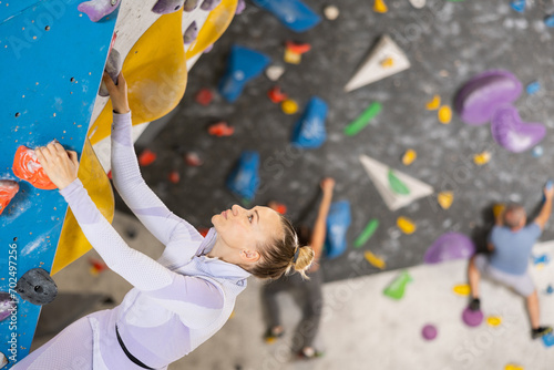 Sports woman on a climbing wall without special safety equipment