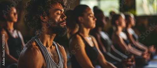 Group of individuals practicing meditation in a yoga session.