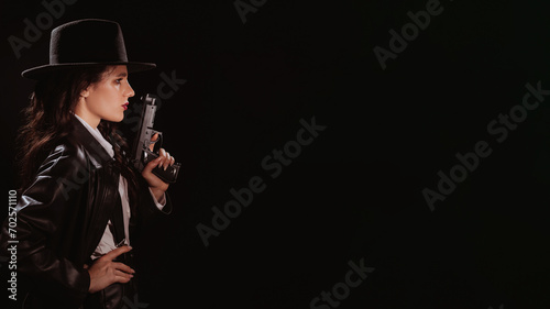 Silhouette of a female detective in a coat and hat with a gun in her hands. A place for your text. A book drama noir portrait in the style of detectives of the 1950s.