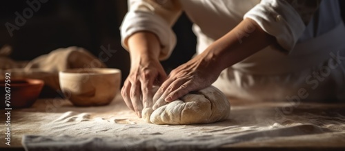 Professional baker woman preparing dough for bread such as sourdough or artisan bread on kitchen table