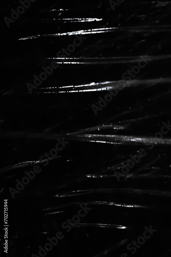 Abstract background. Polyethylene shine. Sparkling drops. Synthetic shine on black