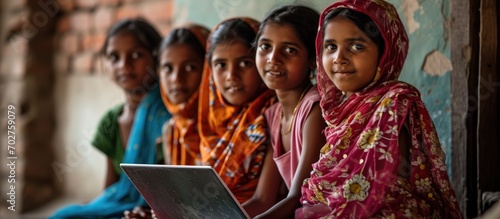 Rural girls receive online education with a laptop.