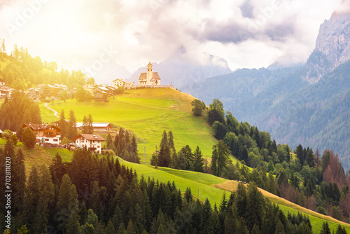 Panoramic view of mountain village with a church in Dolomite alps