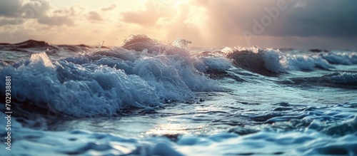 Coastline with waves during sunset. Waves during storm. Wave reaches beach. Splashing ocean waves. Rising storm near seaside.