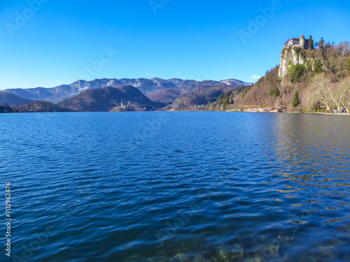 Panoramic view of St Mary Church of Assumption on the small island and castle at alpine lake Bled, Upper Carniola, Slovenia. Serene landscape in remote untouched nature in the Julian Alps in summer