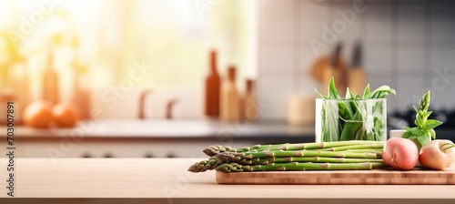 Fresh organic asparagus on wooden table, kitchen background, blurred for text placement