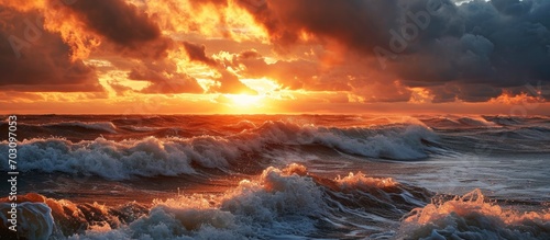 Dramatic sunset sky over Baltic Sea; waves, epic seascape, storm aftermath. Cyclone, meteorology, climate change impact.