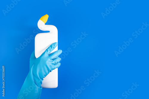 Sanitary supply, hand with cleaner in a bottle, window and toilet detergent,blue background
