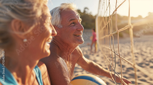 Active senior couple on a volleyball court at the beach
