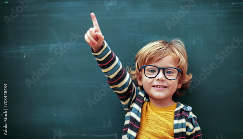 child pointing up on blackboard