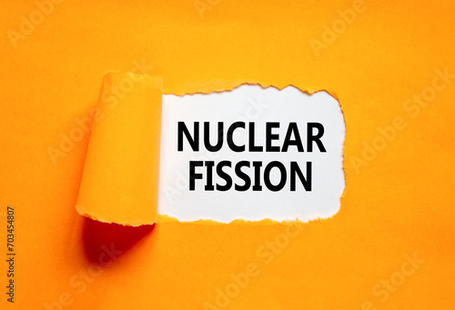 Nuclear fission symbol. Concept words Nuclear fission on beautiful white paper. Beautiful orange paper background. Business science nuclear fission concept. Copy space.