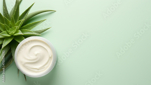 Jar of cream with aloe vera on green background, top view