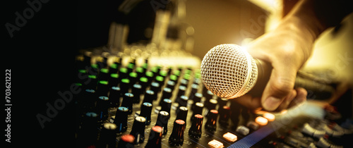 Hand DJ holding microphone on sound mixer in live broadcasting studio producer for sound record control system production and audio equipment and music instrument speaker.